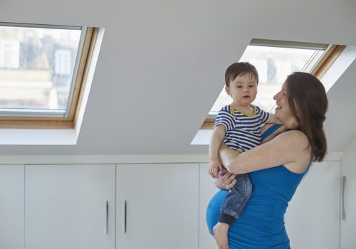 Side view of pregnant mother holding baby boy